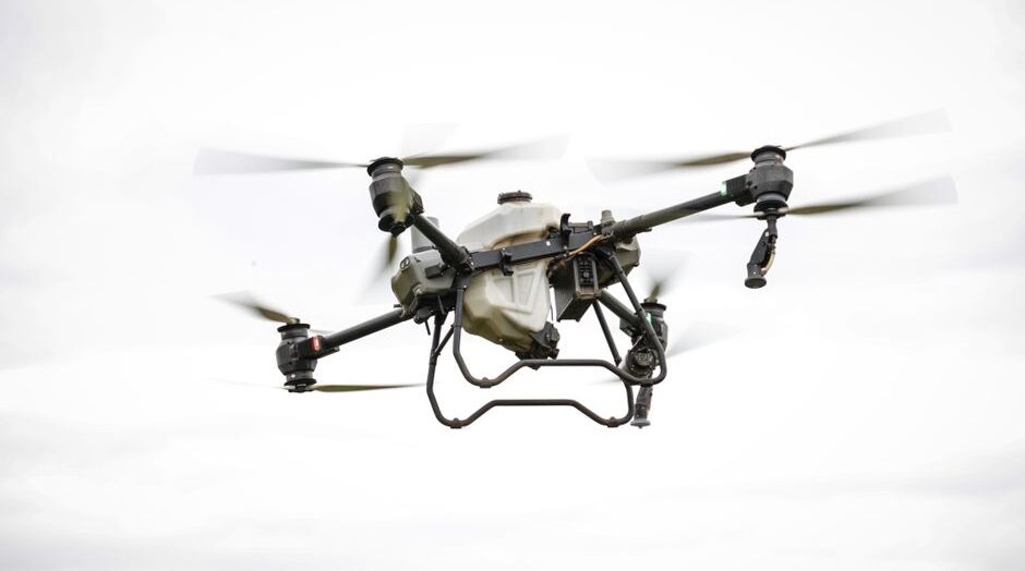 Aerial view of a surveying drone flying over a landscape for mapping and data collection.