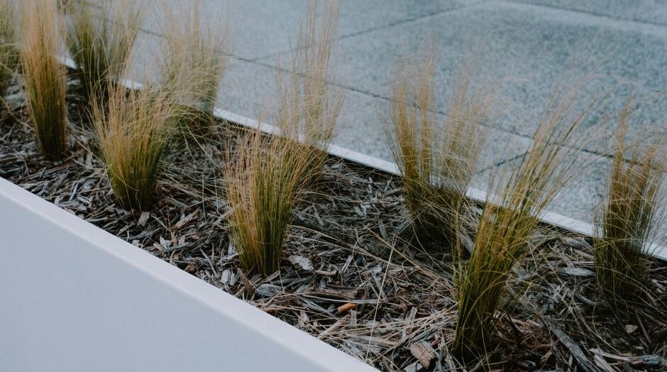 Een moderne tuin met verschillende stalen plantenbakken en kleurrijke bloemen, perfect voor inspiratie in tuinontwerp.